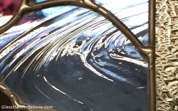 Close up of light reflection on stained glass panel.